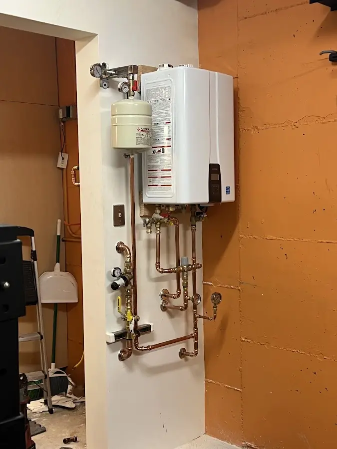 Plumbing technician inspecting water heater connections in Montebello